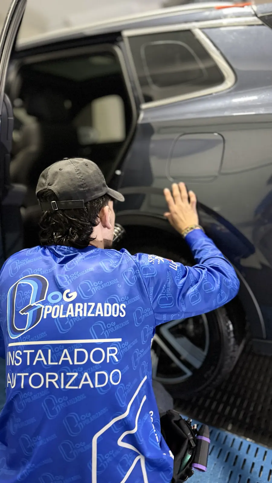 Técnico de OG ajustando película en la carrocería de un vehículo