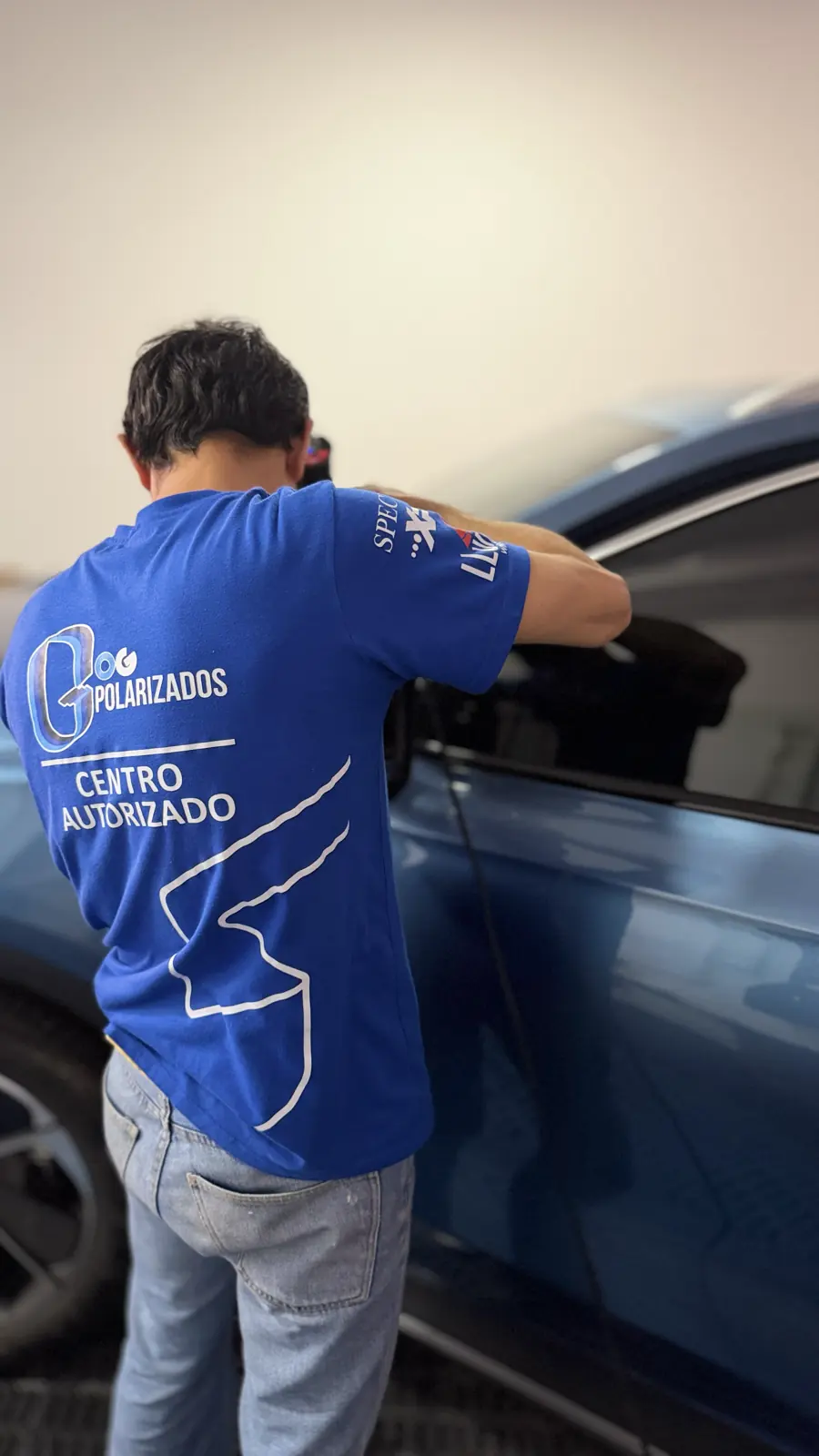 Técnico de OG trabajando sobre la ventanilla de un vehículo